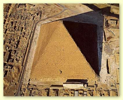 An excellent view of the Great Pyramid of Khufu showing the solar boat memorial in front and other boat pits to the side